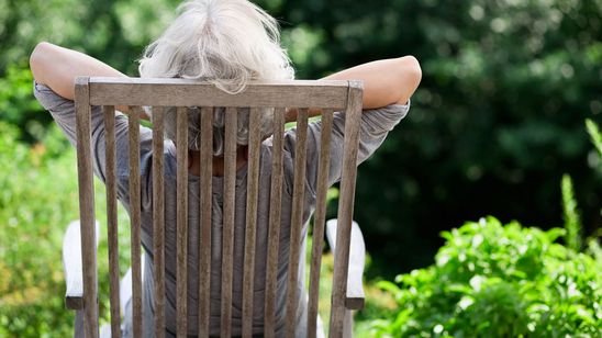 grauhaarige Frau entspannt im Garten